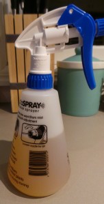 Spray bottle filled with lemony vinegar.